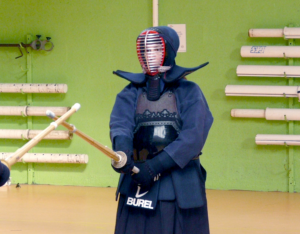 Coline, portant une armure de kendo, en garde